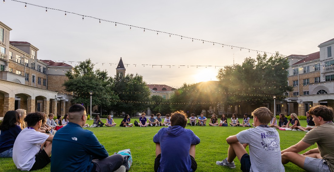 Students sitting on the Commons lawn in a circle